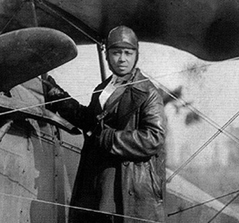 Bessie Coleman standing next to her plane