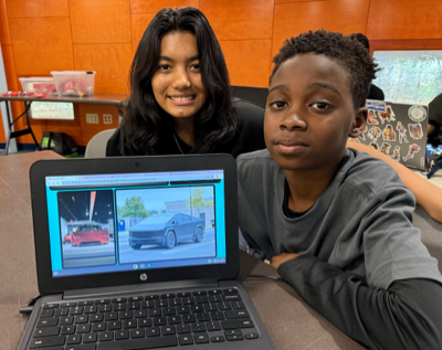 Assistant Instructor Reyanshi with a Girls Code Savannah beginner student who is displaying their newly-built website